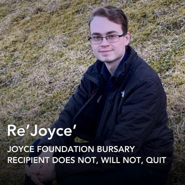 Male student dressed in black sitting on the grass